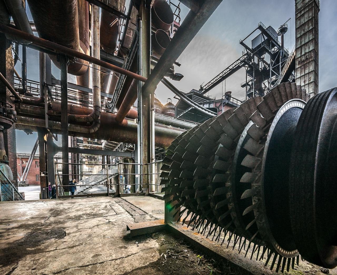 Detailed view of large industrial machinery in a factory with steel structures and pipes.